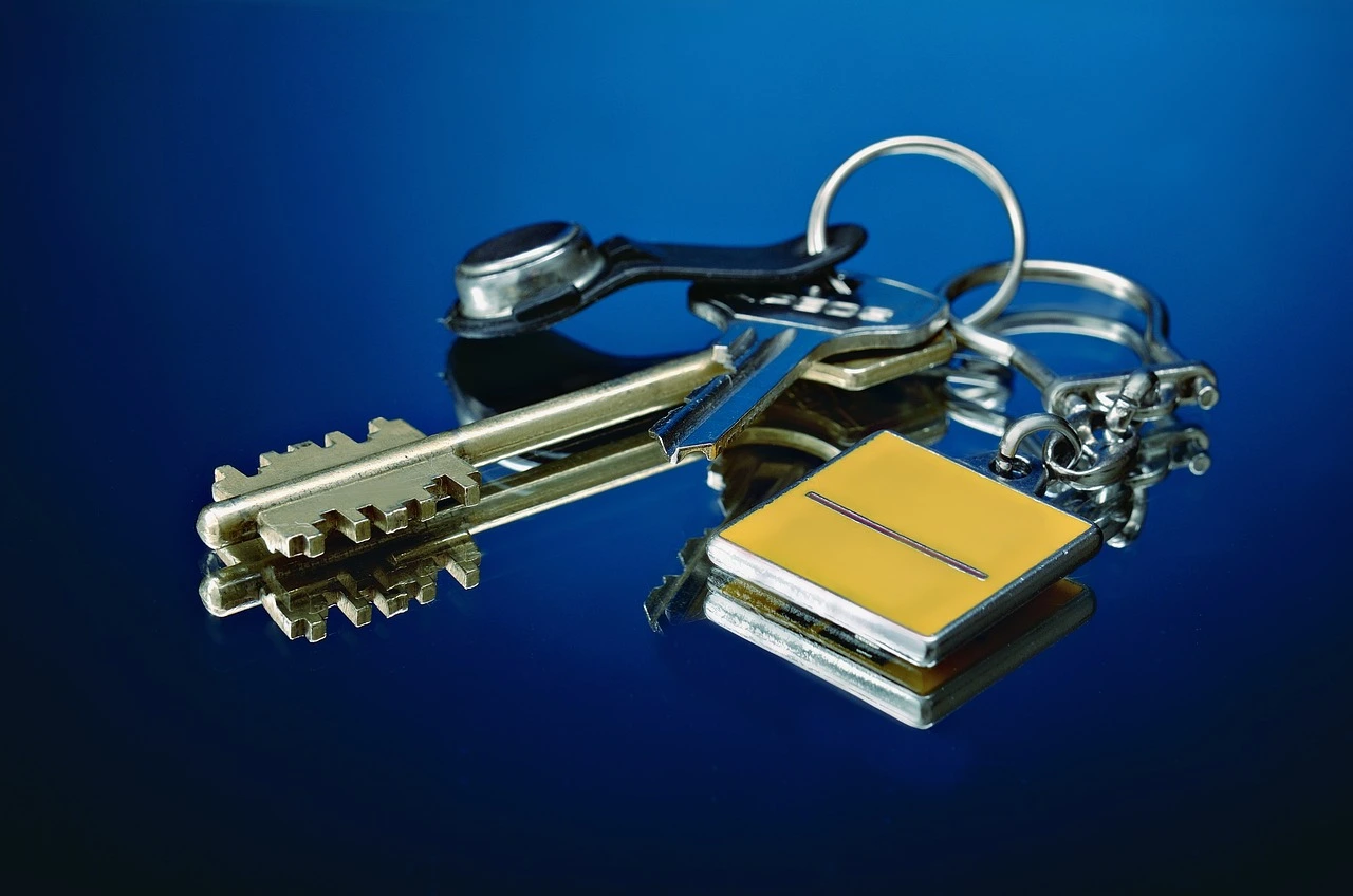 Klucze domowe znajdujące się na niebiesko-czarnym tle.